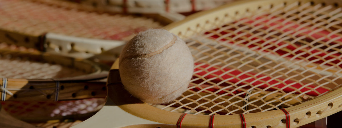 Klassische Vintage-Holztennisschläger mit weissem Tennisball im Querformat