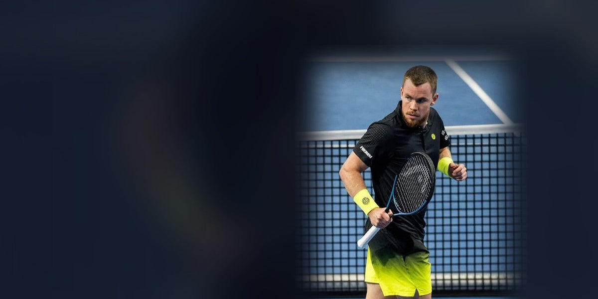 Remy Bertola ballt mit dem Tennisschläger in der Hand die Faust auf dem blauen Hartplatz vor dem Netz